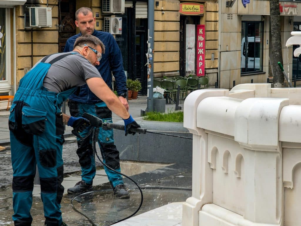Profesional limpiando patio exterior con hidrolavadora